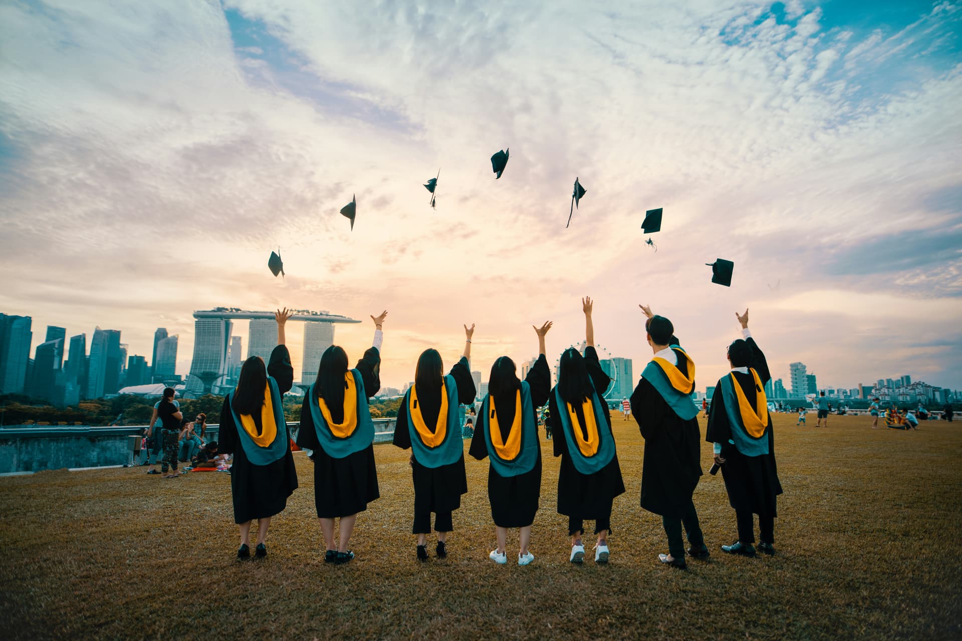 Graduates celebrating at sunset